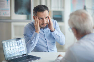 Man explaining his headache to doctor