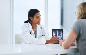 Doctor pointing out a patient's spinal scan
