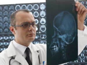 Male neurosurgeon looking x-ray.