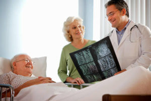 Senior couple discussing X-ray with spine surgeon.