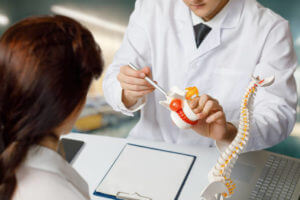 Orthopedic doctor consulting a patient in the office about vertebral hernia.