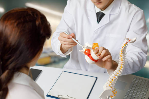 Orthopedic doctor consulting a patient in the office about vertebral hernia.