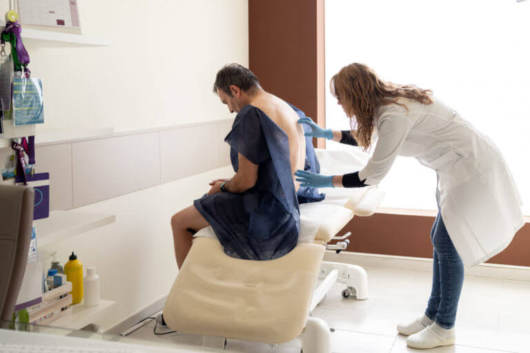 A spine surgeon checking the spine of a patient.