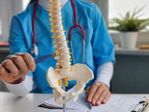 A surgeon performing neurosurgery and operations on the spinal cord while explaining spinal surgery options.