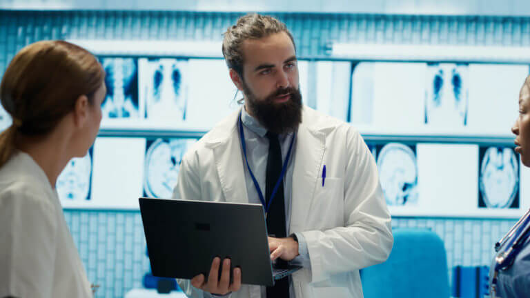 A group of neurosurgeons is reviewing the MRI brain scan results of a patient.