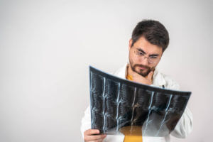 A male spine surgeon is looking at MRI scan in hospital.